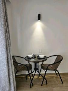 a dining room table with two chairs and a lamp at Pinnacle suites in Nairobi