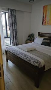 a bedroom with a large bed with a window at Pinnacle suites in Nairobi