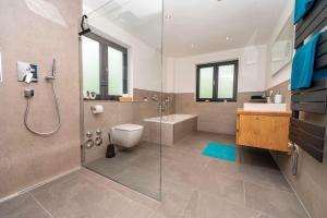 a bathroom with a shower and a toilet and a sink at Ferienwohnung Stuibock in Fischen +35 photos