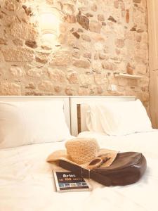 a hat and a book sitting on a bed at Le Bel Angle in Arles