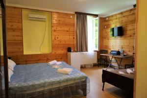 a bedroom with a bed and a table and a desk at MAKO in Racha in Ambrolauri