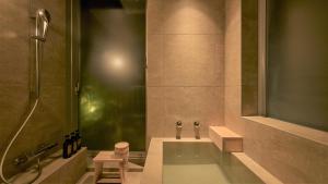 a bathroom with a bath tub and a shower at KÚON Hakone Gora in Hakone