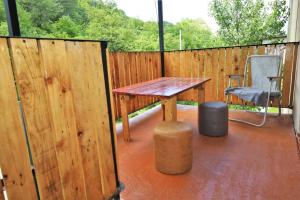 a wooden deck with a wooden table and a chair at MAKO in Racha in Ambrolauri