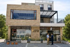 two men standing in front of a building at Lago Verde Elit in Paipa