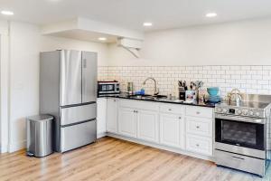a kitchen with white cabinets and a stainless steel refrigerator at Narrow Gauge Nook in Durango