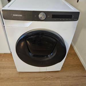 a white washing machine sitting on a wooden floor at Residence Oosterhout in Den Hout