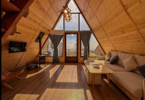 a living room with a couch and a large window at IN CLOUDS RESORT Byurakan in Antarut