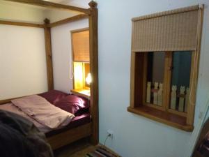 a small bedroom with a bed and a mirror at Хатуля in Oleshnya