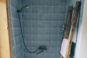 a shower with a hose in a blue tile bathroom at Хатуля in Oleshnya