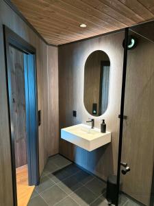 a bathroom with a white sink and a mirror at Aa-Gård in Tennevoll