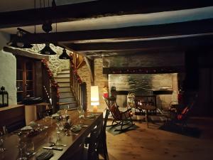 a dining room with a table and a fireplace at Sans Chichi Chambres Et Table in Escandolières