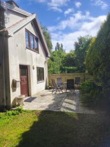 a patio with chairs and a table in front of a house at Lugnt gästhus nära hav, natur och vandring in Glumslöv