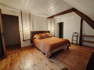 a bedroom with a bed and a wooden floor at Sans Chichi Chambres Et Table in Escandolières
