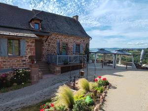 a brick house with a patio and some plants at Sans Chichi Chambres Et Table in Escandolières