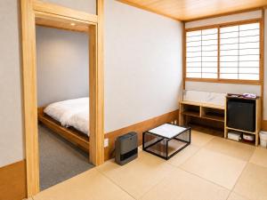 a room with a bed and a mirror and a television at Zao Sunvalley Hotel in Yamagata