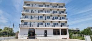a tall white building with balconies on it at Blue Sky Hotel in Eforie Nord