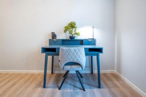 a blue desk with a chair and a plant at Lit Living - Deluxe Apartments - Box Spring - Parking - Neueröffnung - NEW OPENING in Worms