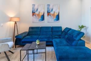a blue couch in a living room with a table at Lit Living - Deluxe Apartments - Box Spring - Parking - Neueröffnung - NEW OPENING in Worms