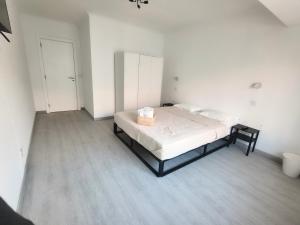 a bedroom with a bed in a white room at Cubo Rooms Olhão in Olhão
