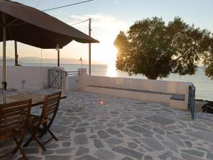 a patio with a table and chairs and the ocean at Seaside Studios in Megalochori