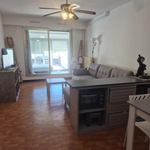 a living room with a couch and a table at Studio avec grande terrasse in Carnon-Plage