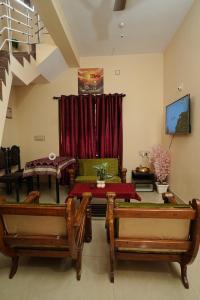 a living room with two tables and a couch at SM Cottage in Mangalore
