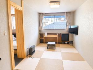 a room with a room with a desk and a television at Zao Sunvalley Hotel in Yamagata