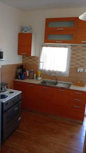 a kitchen with wooden cabinets and a sink and a window at red caravan in Nea Potidaea