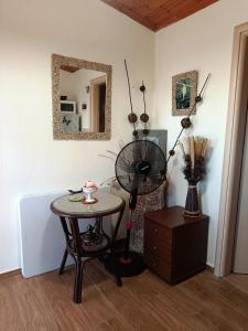 a room with a table with a fan and a mirror at red caravan in Nea Potidaea +10 photos
