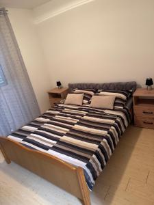 a large bed in a bedroom with two pillows on it at Apartman J&B in Vir