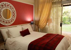 a bedroom with a bed with a red wall at Blessings Guesthouse in Newcastle