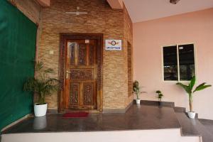 a wooden door in a room with potted plants at SM Cottage in Mangalore