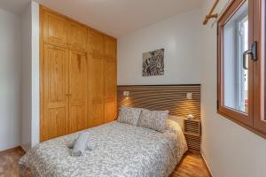 a small bedroom with a bed and a window at Las Sirenas 2 in Las Palmas de Gran Canaria