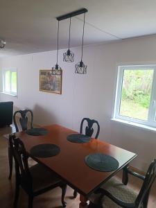 a dining room table with four chairs and a window at Senja Aurora in Senja