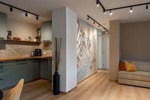 a kitchen and living room with a large painting on the wall at Mountain View Apartment, Free Parking, Hiking Nearby in Ålesund