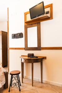 a wooden table with a tv on a wall at Agriturismo La Baita in Agerola