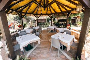 an outdoor restaurant with white tables and chairs at Agriturismo La Baita in Agerola