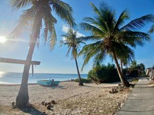 a cross on a beach with palm trees and a boat at Tirosa in Nembrala +29 photos