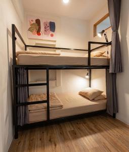 two bunk beds in a room with wooden floors at Bangkok Sanookdee Hostel in Bangkok