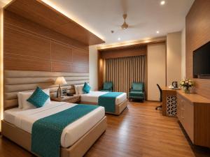 a hotel room with two beds and a television at Landmark, Rewa - AM Hotel Kollection in Rewa