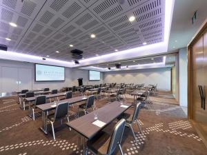 a lecture hall with tables and chairs and a podium at Pullman Adelaide in Adelaide +114 photos