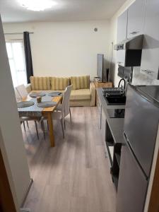 a kitchen and living room with a table and a couch at Apartman J&B in Vir