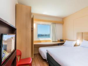 a hotel room with two beds and a window at ibis Puerto Montt in Puerto Montt