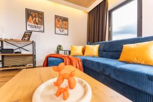 a living room with a blue couch and a table at The Great View Sauna & more in Harscheid