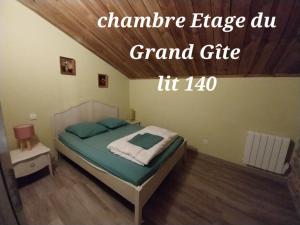 a bedroom with a bed with a green comforter at gîte 19 personnes in Rogues