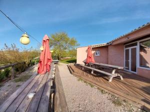 two red umbrellas sitting on a wooden deck at gîte 19 personnes in Rogues