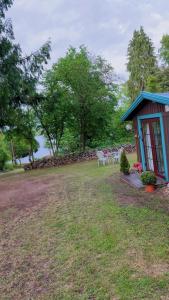 a house with a table and chairs in a yard at BAPA STAYs COZY CABIN A by the Ivö lake in Kristianstad