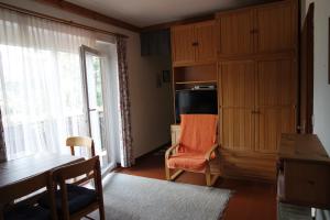 a living room with a table and a chair and a window at Haus Pock Apartments in Lake Pressegg +12 photos