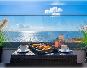 a tray of food on a table in front of a window at VILLA HELENA Amber Apartment in Caniço