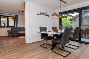 a dining room and living room with a table and chairs at Ferienwohnung Stuibock in Fischen